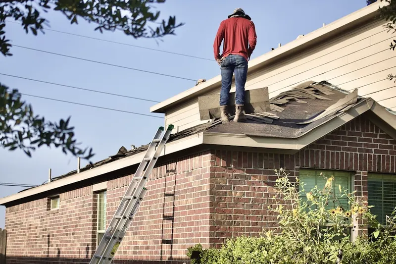 Professional roofer working on a residential roof in North Kenwood